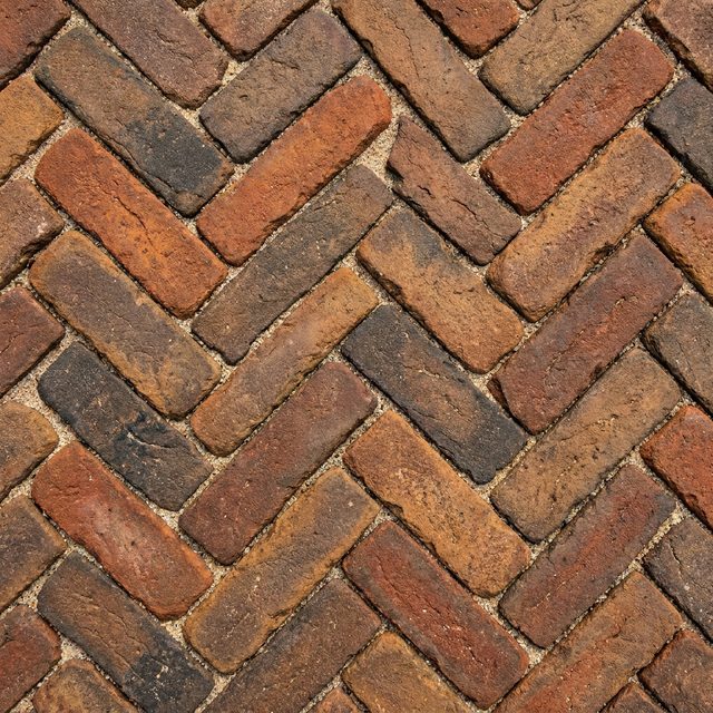 Tumbled clay pavers laid tight in a herringbone pattern